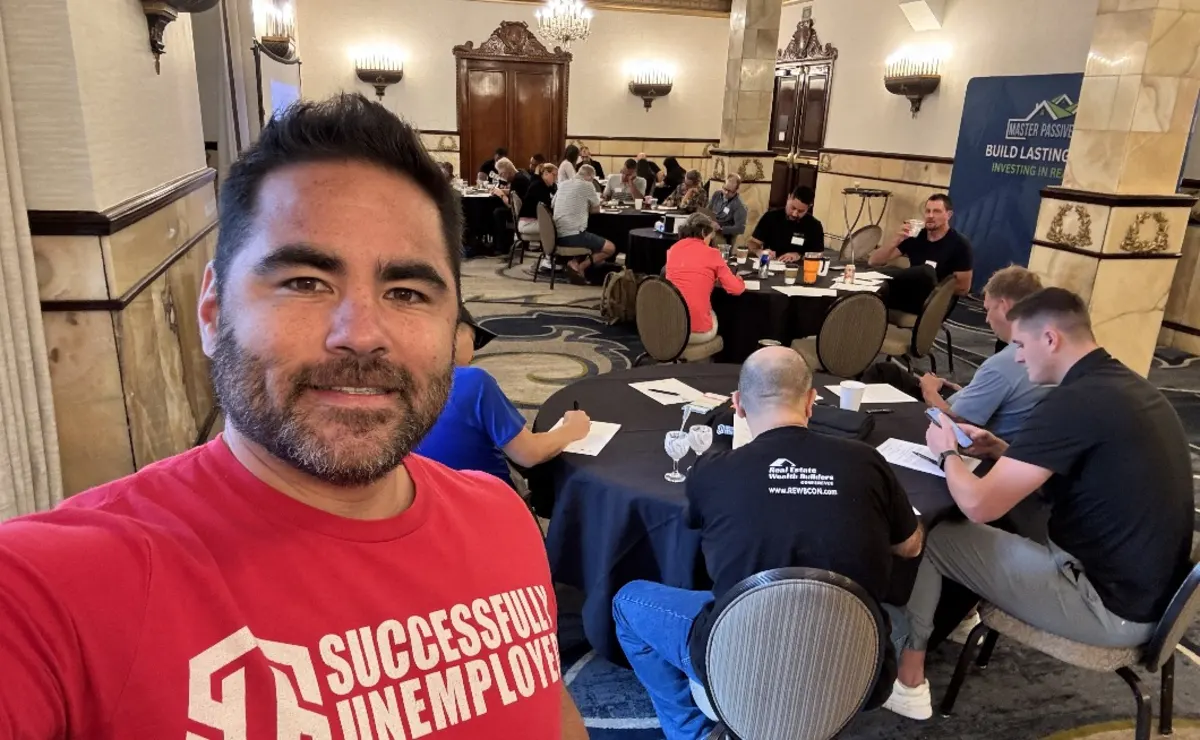 Dustin Heiner at a mastermind workshop with investors working at round tables