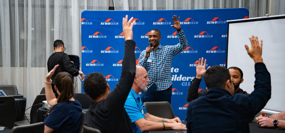 Investors raising their hands during a live mastermind session