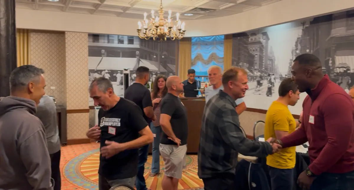 Real estate investors networking and shaking hands at a mastermind event